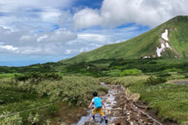 小川をトレッキングする子ども