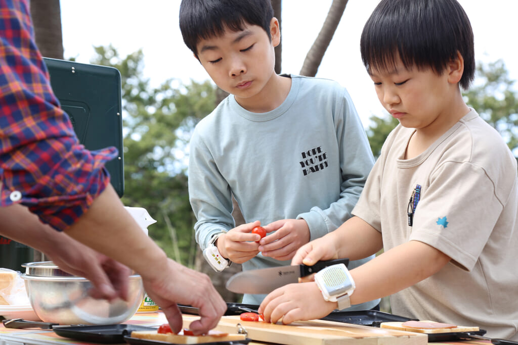 キャンプで料理する親子