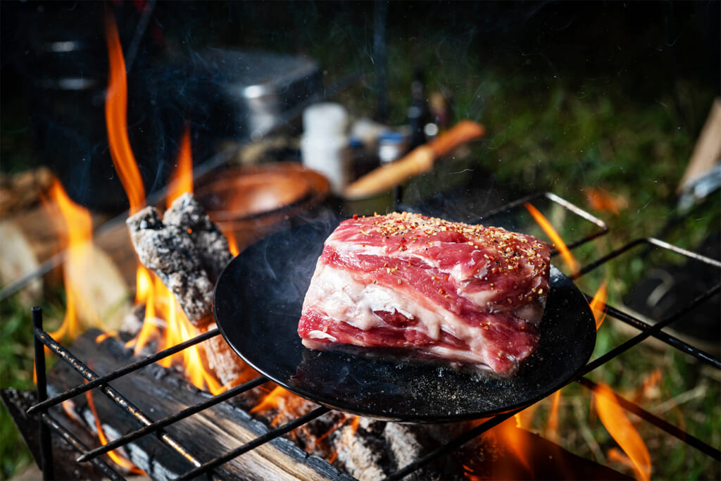 焚き火で焼くラム肉の肩ロース