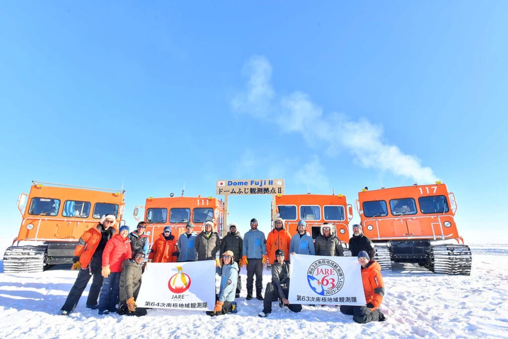 雪上車をバックに南極地域観測隊の記念撮影