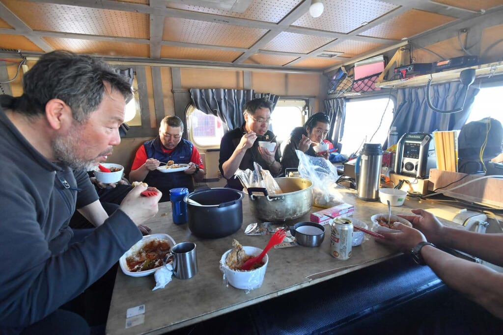 雪上車の車内で食事をとる隊員