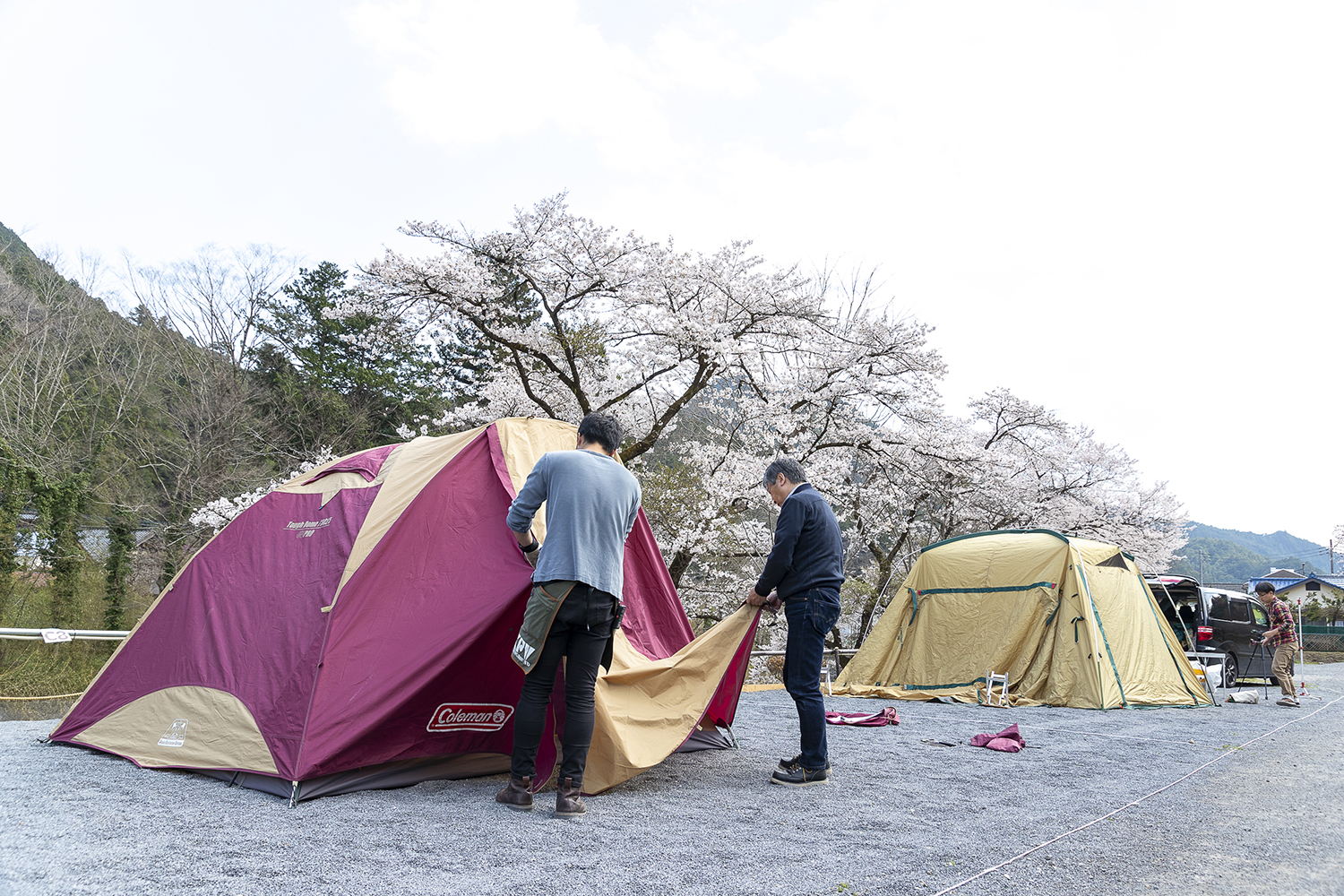 キャンプインストラクターにテントの張り方をガイドしてもらっているところ