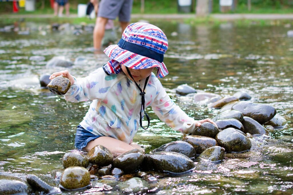 河原で水遊びする幼児