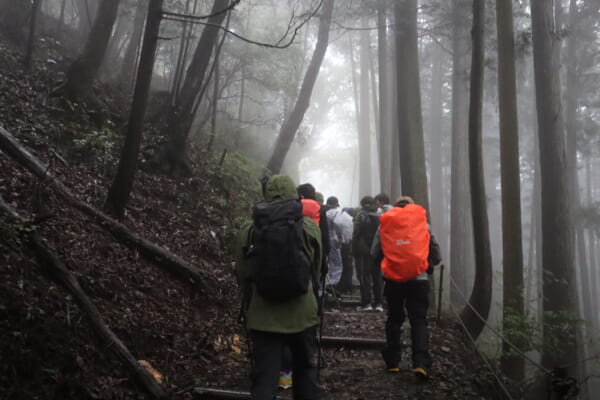 御岳山の雨で幽玄な雰囲気が漂う山を参加者の方々と共に登っていく
