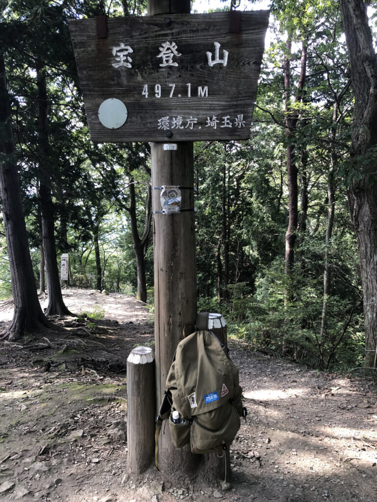 山頂看板にザックをかけて記念写真