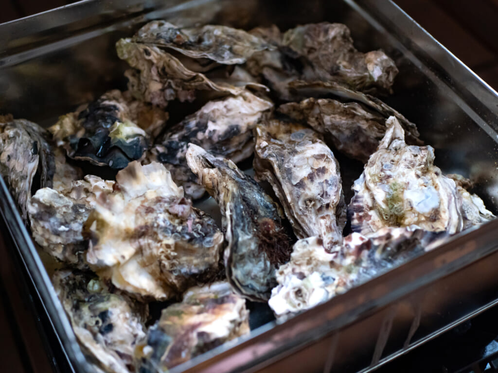 一斗缶をつかった蒸し牡蠣料理のカンカン焼き