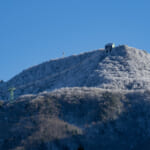 うっすらと雪に覆われた山とロープウェイ