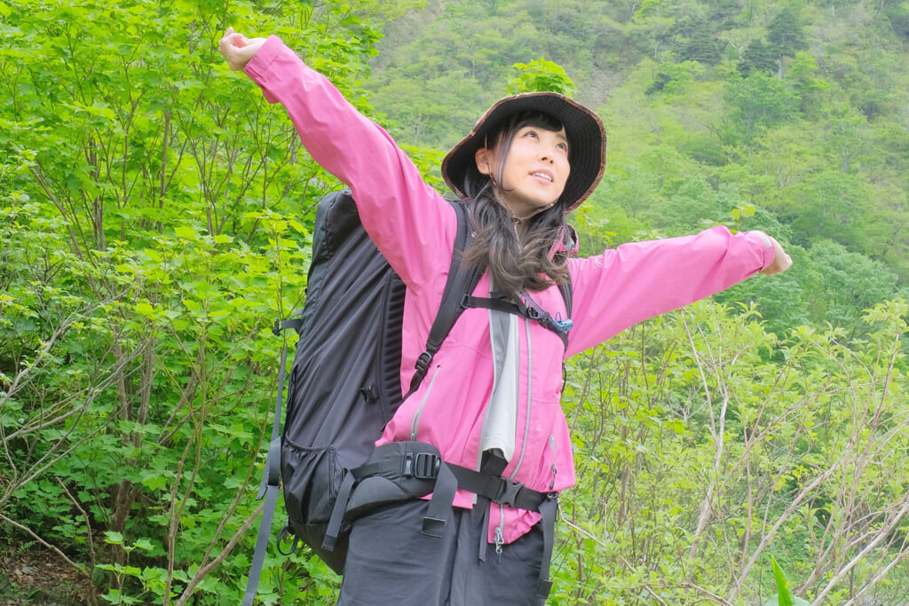 登山中に深呼吸をする女性