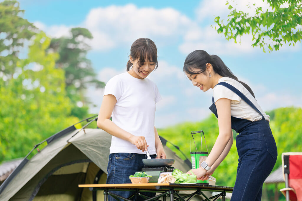 キャンプで料理する女性キャンパー