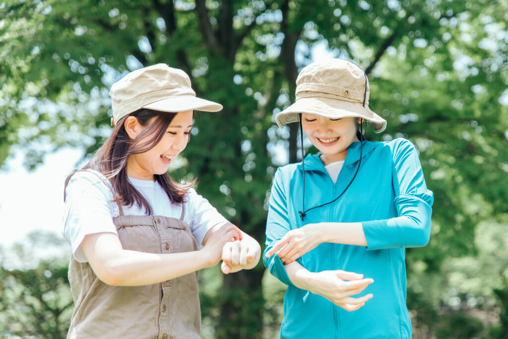 虫よけ対策する女性キャンパー