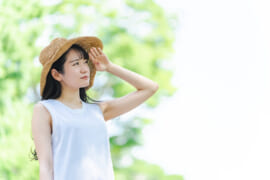 日差しを浴びて暑がってる人