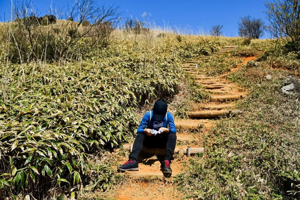 登山道で座る人AC