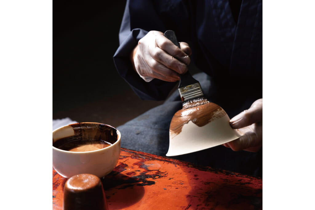 塗師が漆を塗っている