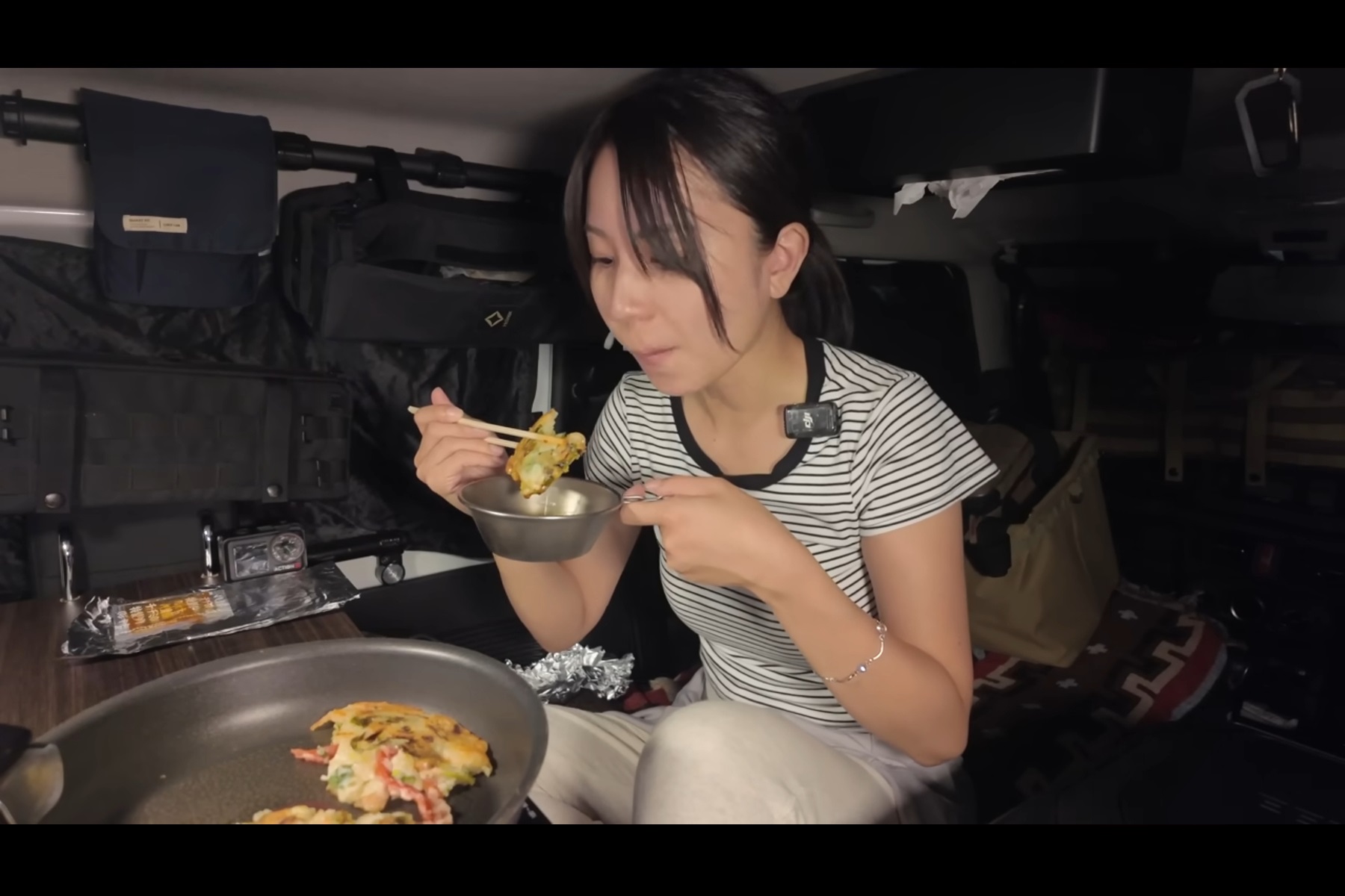 ジムニーの車内で海鮮チヂミを頬張る「まややん」さん